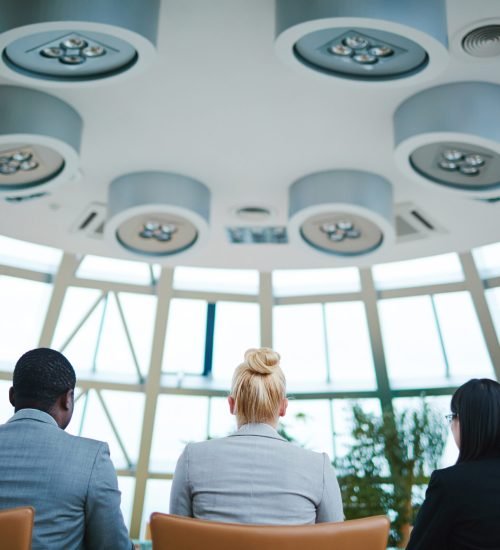 Rear view of managers sitting on chairs at conference